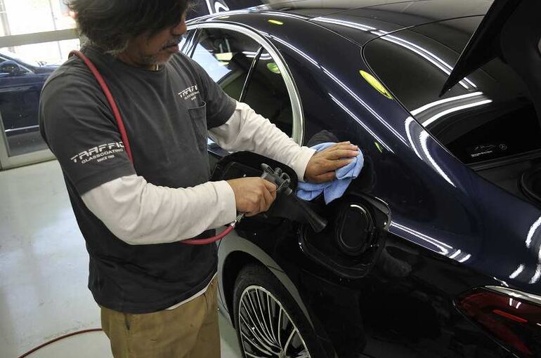 メルセデスベンツE350eの画像。シャンプー洗車後に給油口の水滴をブロワーで除去している写真。　