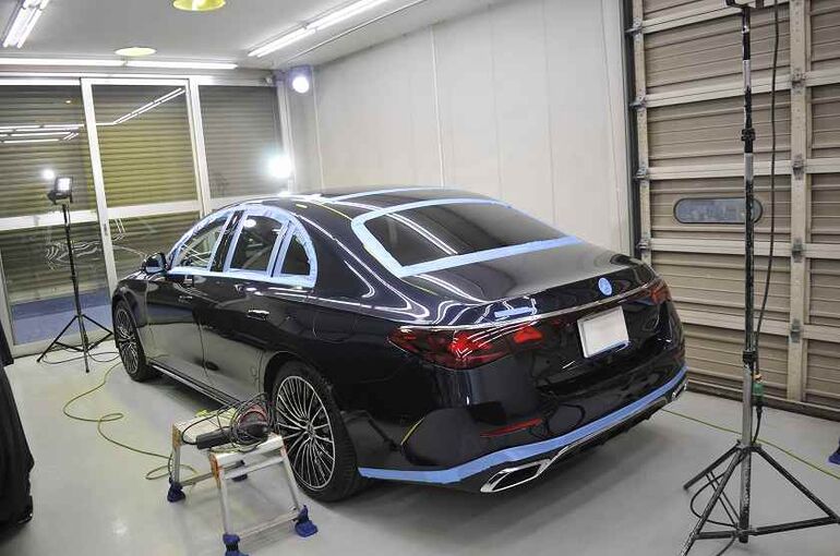 メルセデスベンツE350eの画像。 磨き施工前に特殊ライトをセッティングしたところ。左後ろから車両全体と特殊ライトを撮った写真。