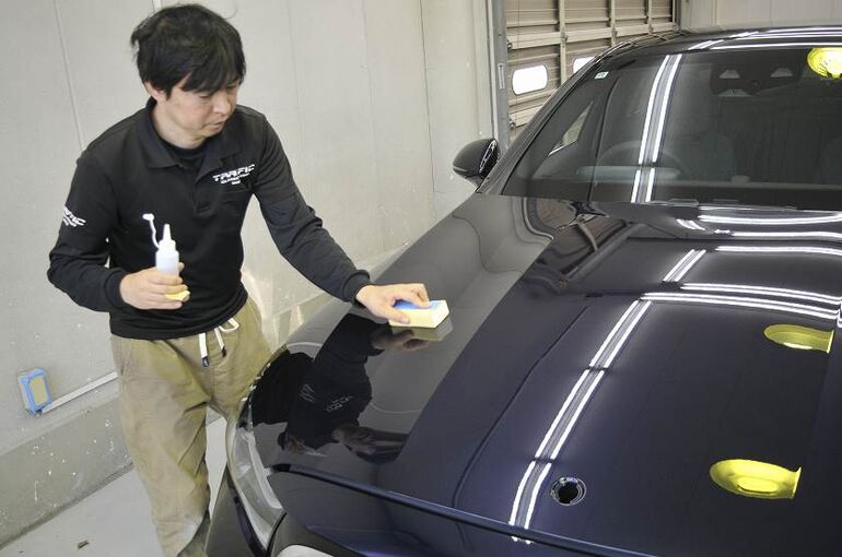 メルセデスベンツE350eのカーコーティング施工中の画像。ボンネット部にコーティング剤の塗布している写真。