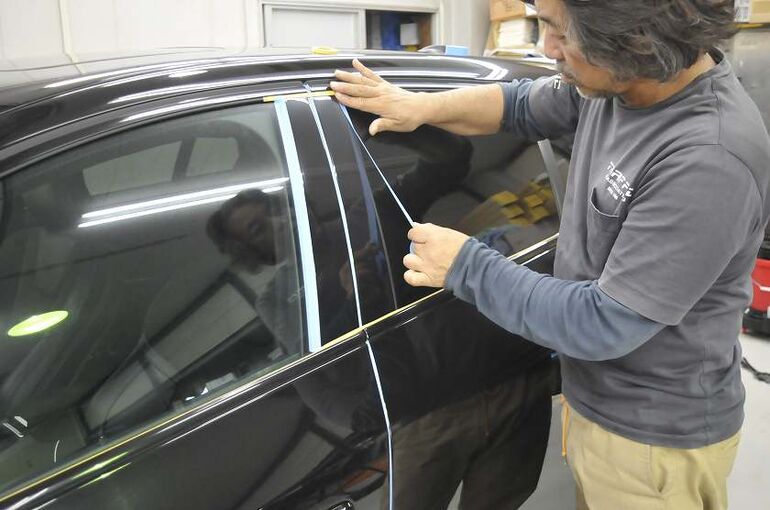 ボルボV60の、磨き施工前にパーツの隙間などを養生している写真