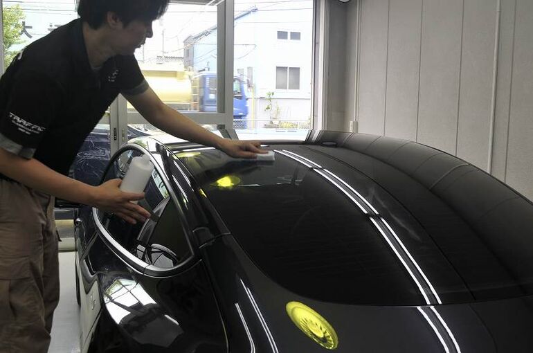 テスラモデル３のカーコーティング施工中の画像　ルーフ部のガラス面に撥水コーティングを塗布している写真